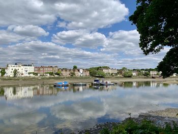 Scenic view of lake by buildings against sky