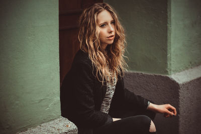 Portrait of young woman sitting at home