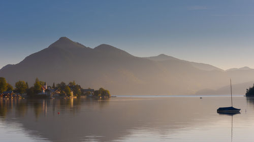 Scenic view of lake by mountains against clear sky