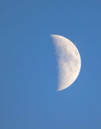 Low angle view of moon against clear blue sky