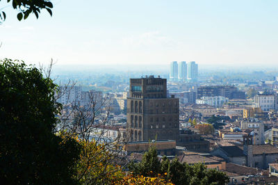 Cityscape by sea against sky