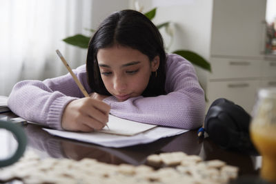 Girl doing homework at dining table