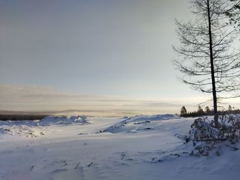Scenic view of snow covered field against sky