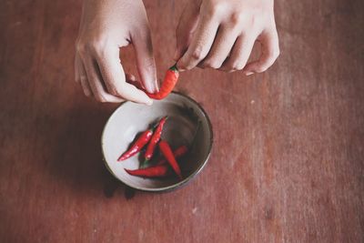 High angle view of hand holding bowl on table