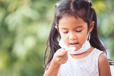 Close-up of girl taking syrup in spoon
