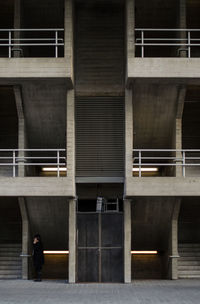 Man standing outside of building with stairs behind him, side profile