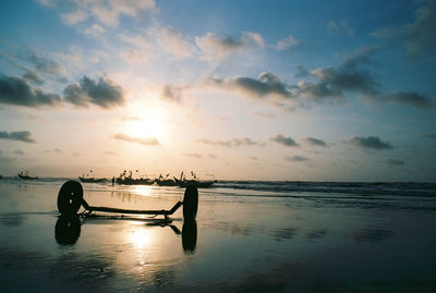 Silhouette boat in sea against sky during sunset