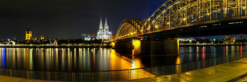 Illuminated bridge over river at night