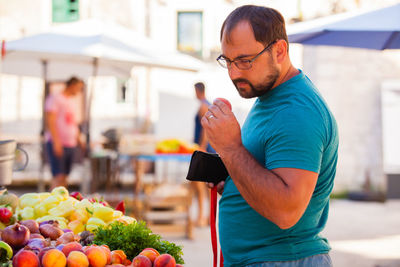 Full length of man holding fruits at market