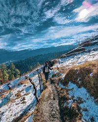 Rear view of people on snow covered mountain against sky