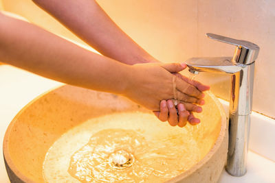 Close-up of woman washing hands in sink