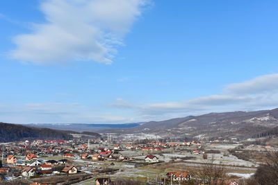 Town by mountains against sky