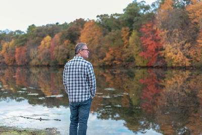 Man standing by lake during autumn