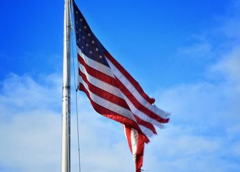 Low angle view of flag against blue sky