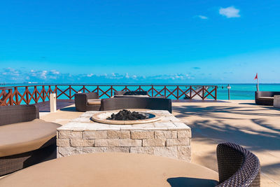 Outdoor open restaurant of chair and stone made table by jetty on sea