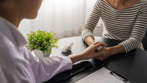 Midsection of woman sitting on table