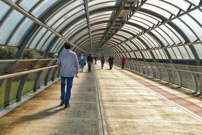 Rear view of people walking on railroad station