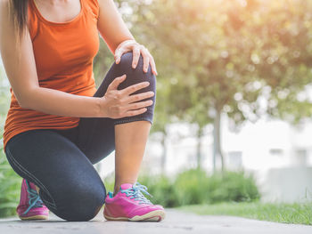 Midsection of woman sitting outdoors