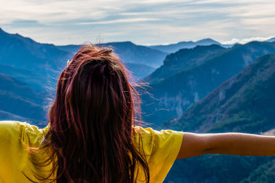 Rear view of woman against mountain range