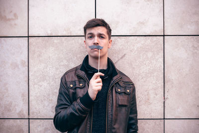 Portrait of man with fake paper moustache