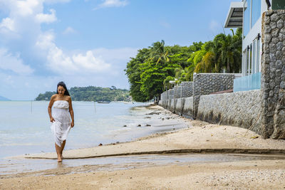 Beautiful woman in white dress walking on the beach in phuket