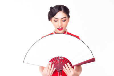 Woman holding red umbrella against white background