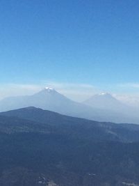 Scenic view of mountains against blue sky