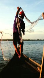 Man jumping in sea against sky