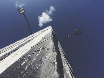 Low angle view of power lines against blue sky