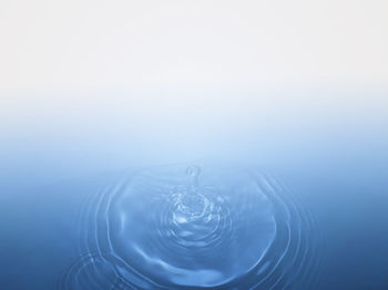 Water splashing against blue background