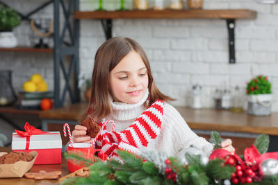 Cute smiling little child girl eating chocolate biscuits and drinking hot cocoa