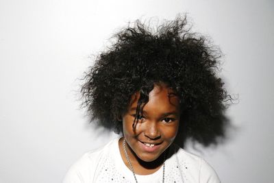 Close-up portrait of girl smiling against white background
