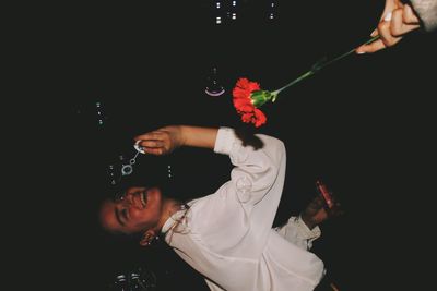 High angle view of people holding red flower