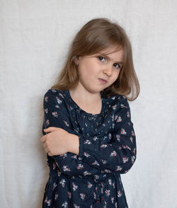 Portrait of teenage girl standing against wall