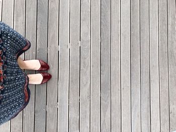 Low section of woman standing on wooden floor