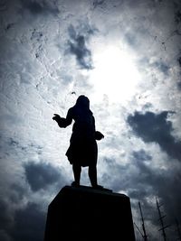 Low angle view of silhouette statue against sky