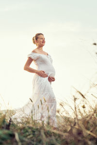 Woman standing on field against sky