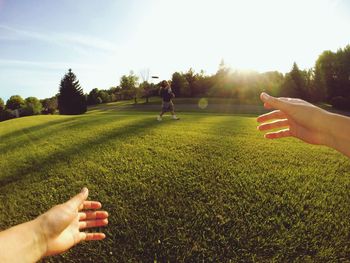 Couple playing with plastic disc on grassy field