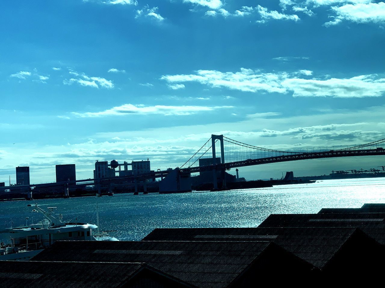 VIEW OF SUSPENSION BRIDGE AGAINST CLOUDY SKY