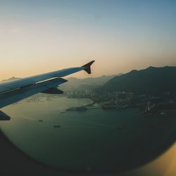 Airplane flying over airport runway against sky