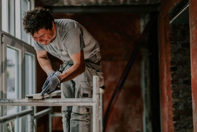 One young man is repairing a window frame. person