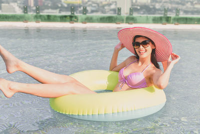 Young woman on inflatable ring in swimming pool