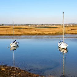 Sailboat on lake against clear sky