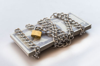 High angle view of padlocks on chain against white background