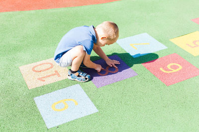 High angle view of boy playing with multi colored umbrella