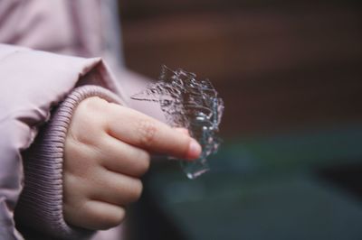 Midsection of child holding ice