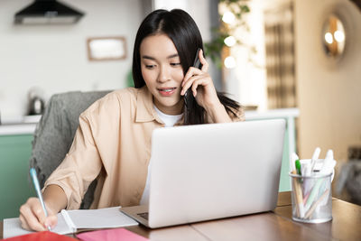 Young woman using laptop at office