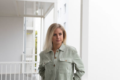 Young woman standing against wall