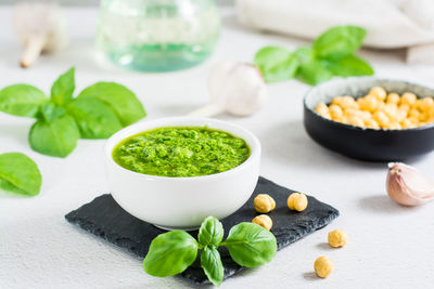 Fresh basil pesto sauce in a bowl on the table. homemade savory snacks