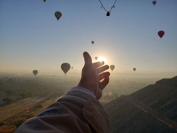 Low angle view of my hand above teotihuacan pyramids and glibes on the horizon